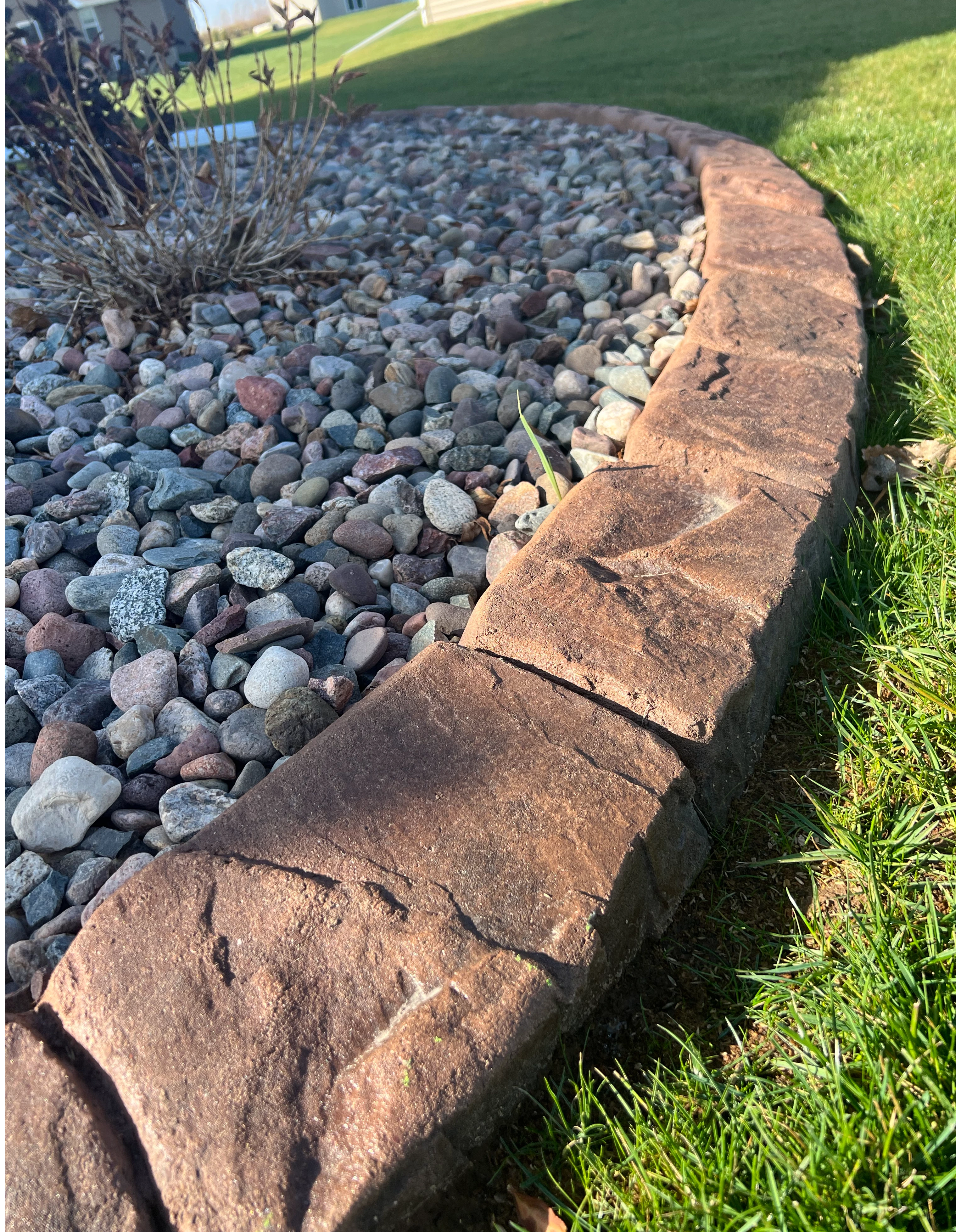 Beautifully landscaped front yard with custom concrete curbing borders around flower beds in the St. Louis area